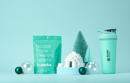 EcoBrite bottle cleaning tablets next to BlenderBottle with tables stacked in igloo formation alongside winter holiday decorations.